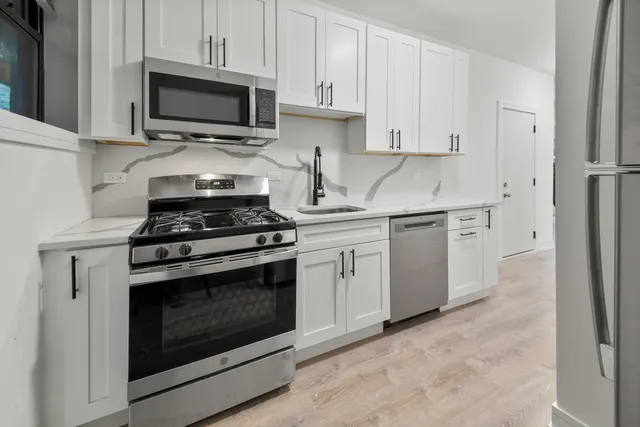 a kitchen with cabinets stainless steel appliances and a sink