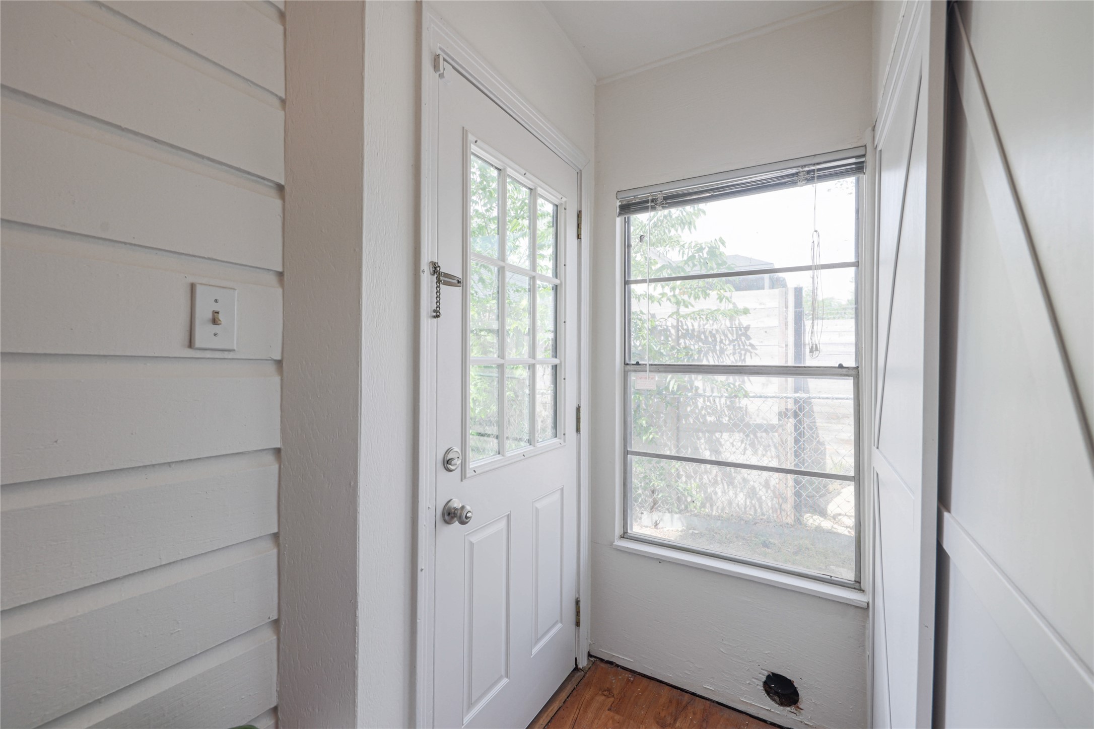 4607 Evans Avenue, Unit B Austin, TX 78751 - Photo 22 of 34 Entryway featuring a paneled door with glass inserts, an adjacent window with horizontal muntins, and wood-finish flooring