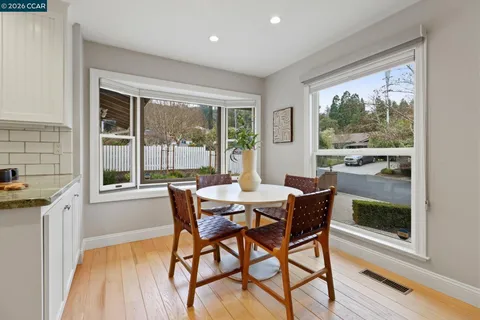 a view of a dining room with furniture a potted plant and wooden floor