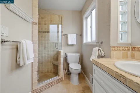 a large white kitchen with a large window and stainless steel appliances