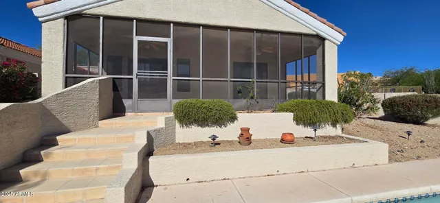 a view of a house with backyard and sitting area