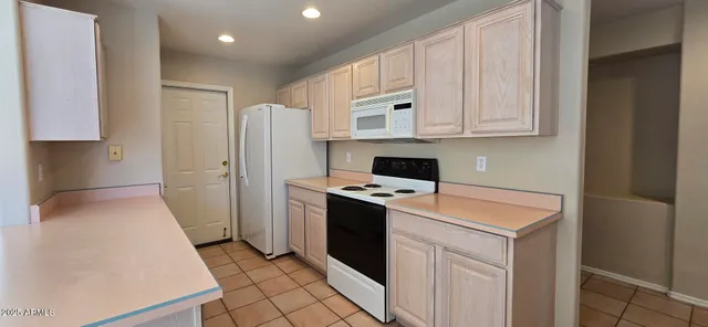 a kitchen with white cabinets and white appliances