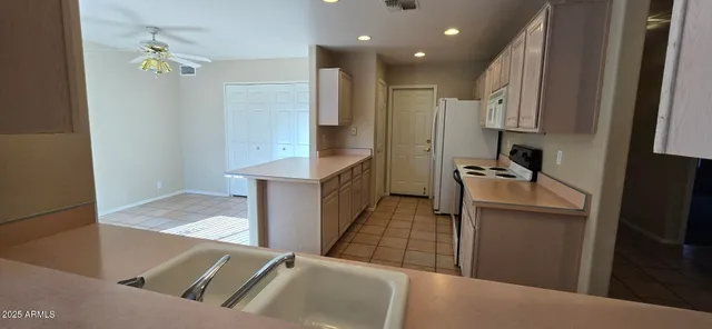 a kitchen with stainless steel appliances kitchen island granite countertop a refrigerator and a sink
