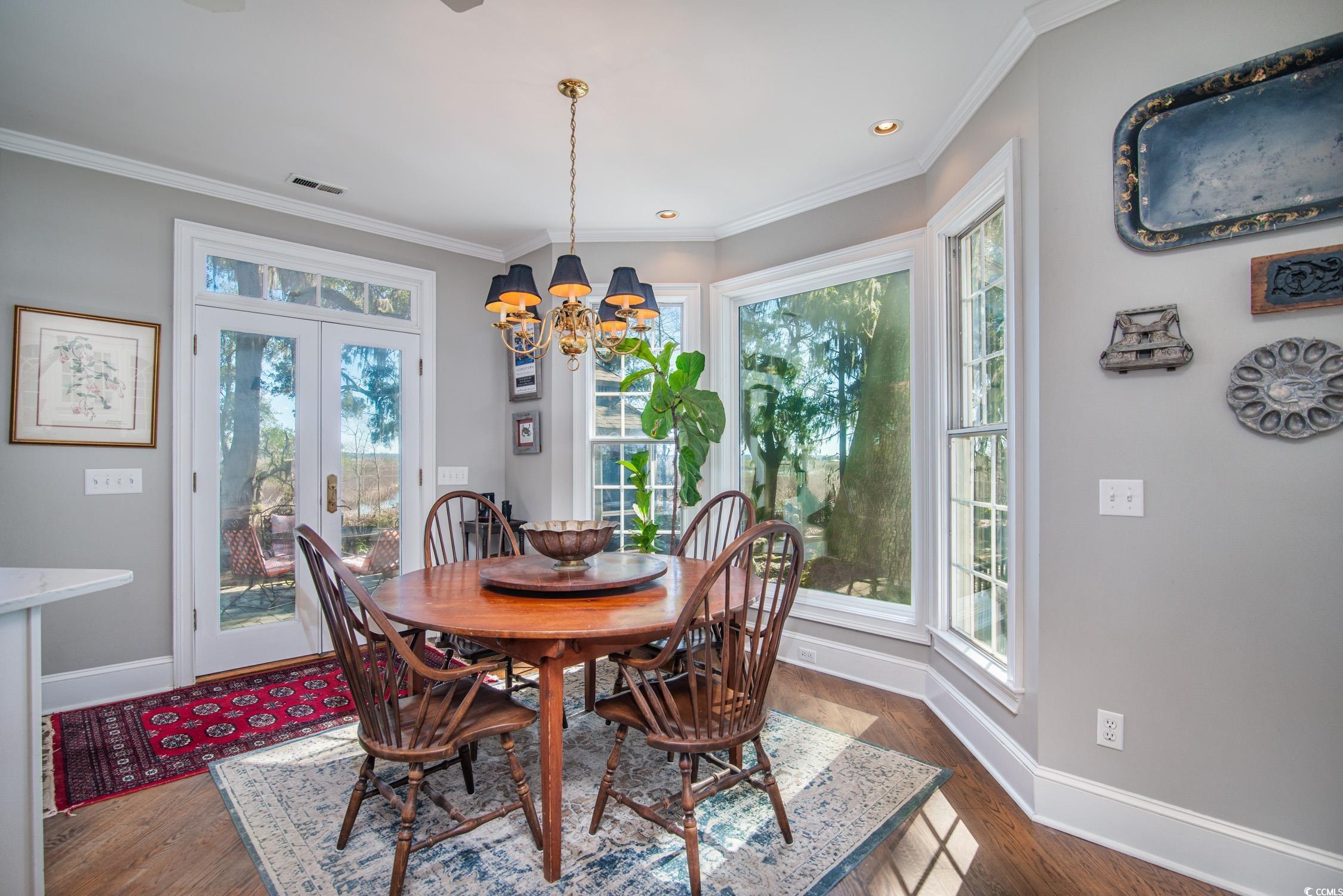 762 Wraggs Ferry Road Georgetown, SC 29440 - Photo 17 of 33 Dining space featuring dark wood-type flooring, crown molding, and baseboards