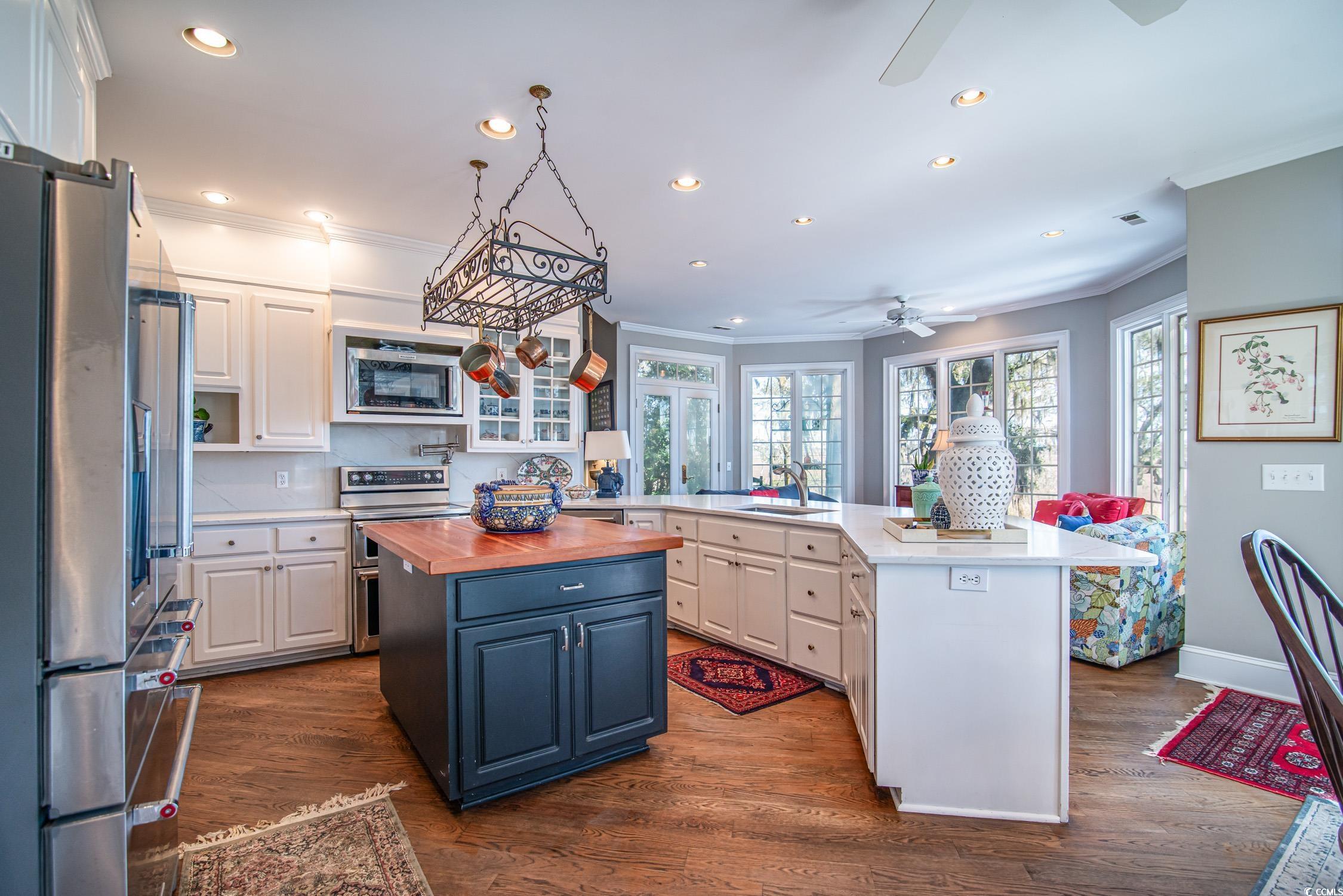 762 Wraggs Ferry Road Georgetown, SC 29440 - Photo 18 of 33 Kitchen featuring a peninsula, butcher block counters, a sink, white cabinets, and appliances with stainless steel finishes