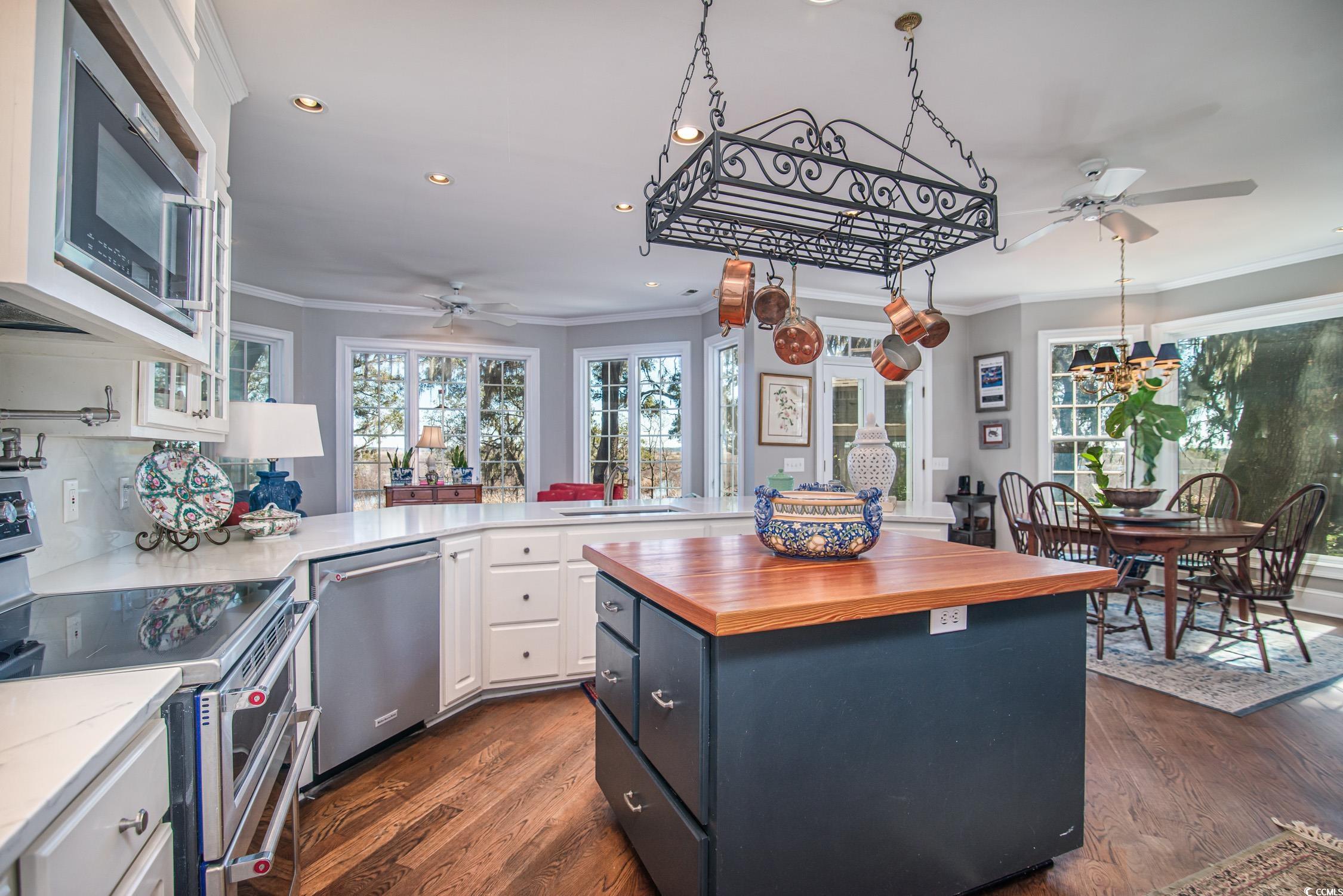762 Wraggs Ferry Road Georgetown, SC 29440 - Photo 19 of 33 Kitchen with white cabinets, butcher block countertops, appliances with stainless steel finishes, dark wood-type flooring, and crown molding