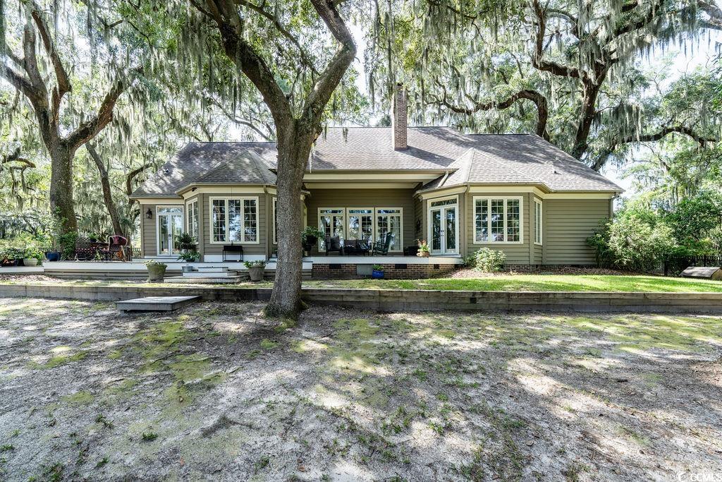 762 Wraggs Ferry Road Georgetown, SC 29440 - Photo 2 of 33 Rear view of house with french doors, a shingled roof, a patio area, a chimney, and crawl space