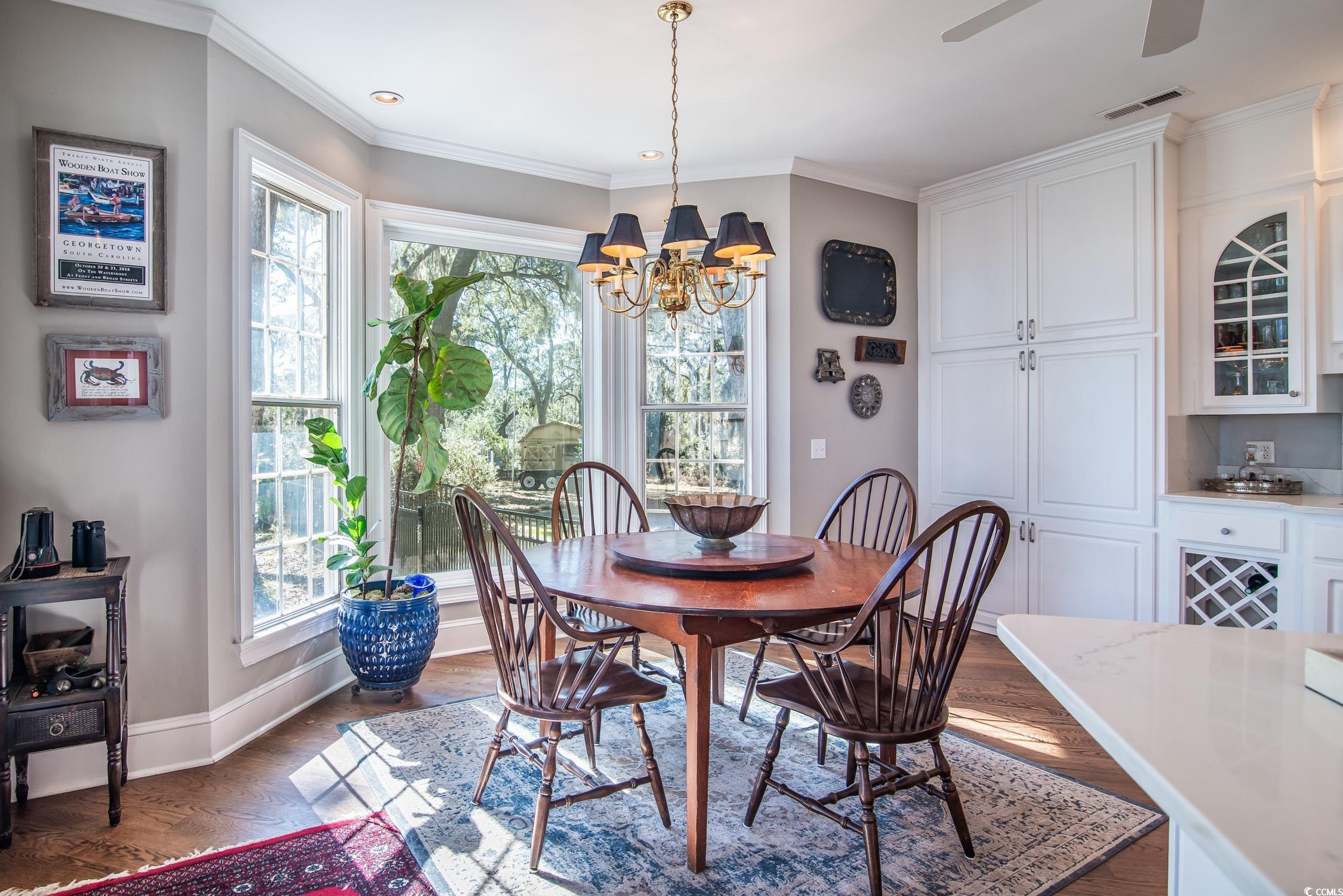 762 Wraggs Ferry Road Georgetown, SC 29440 - Photo 22 of 33 Dining space featuring crown molding, visible vents, plenty of natural light, and baseboards