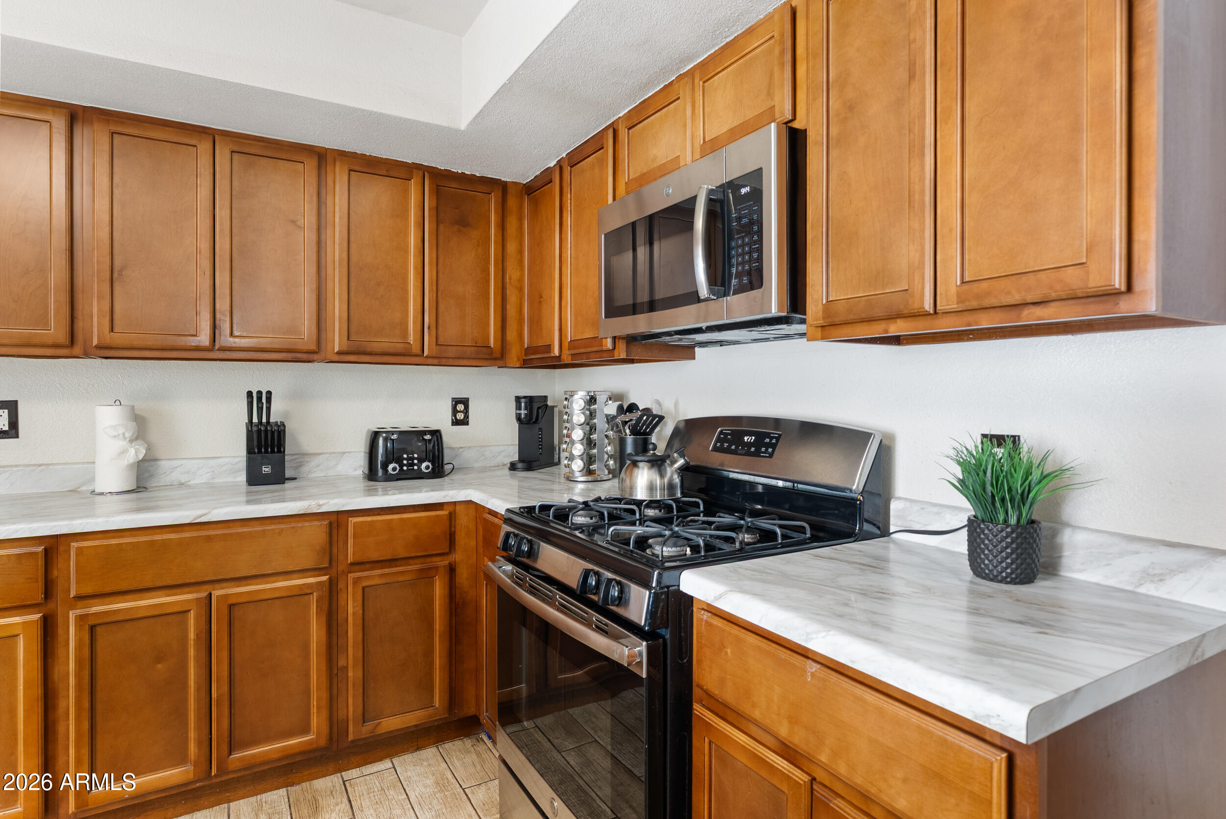3631 West Colter Street Phoenix, AZ 85019 - Photo 11 of 45 a kitchen with stainless steel appliances granite countertop a stove a sink dishwasher and microwave