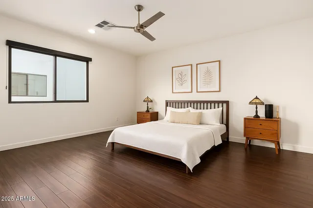 a bedroom with a bed and wooden floor
