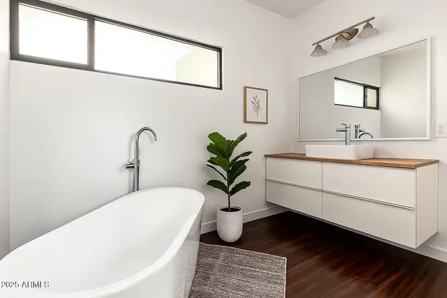 a bathroom with a bathtub a sink and a window