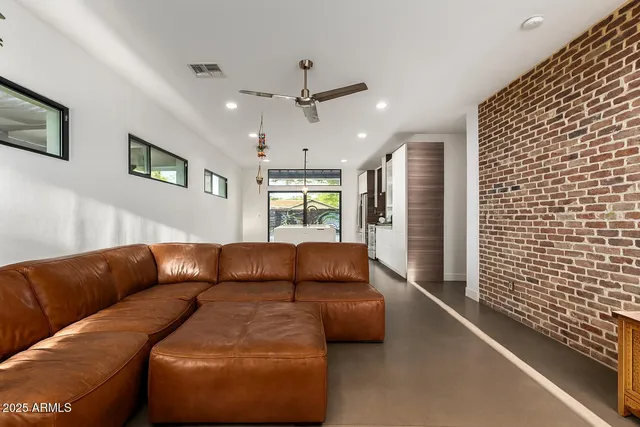 a living room with furniture and a ceiling fan