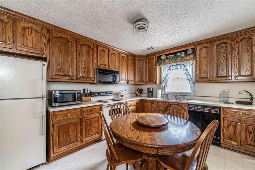 13 Spring Circle Southeast Lindale, GA 30147 - Photo 14 of 25 a kitchen with a stove a sink dishwasher a dining table and chairs