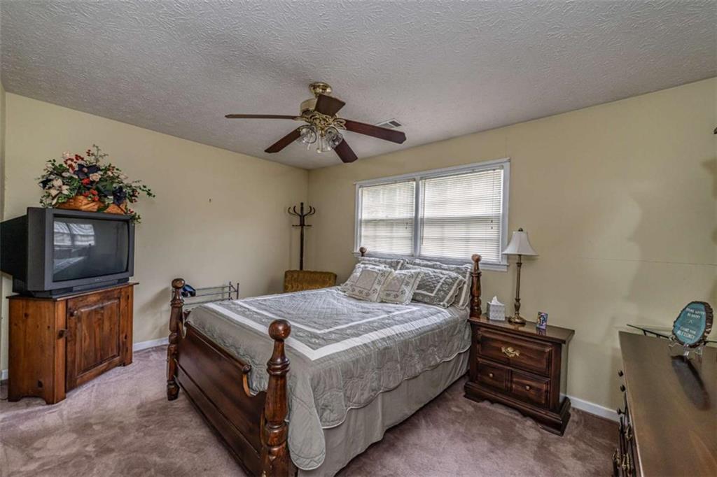 13 Spring Circle Southeast Lindale, GA 30147 - Photo 20 of 25 a bedroom with a bed and a tv on the dresser