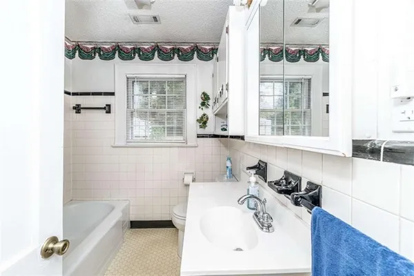 a bathroom with a tub sink and mirror