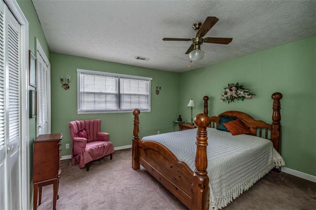 13 Spring Circle Southeast Lindale, GA 30147 - Photo 24 of 25 a bedroom with a bed and a chandelier