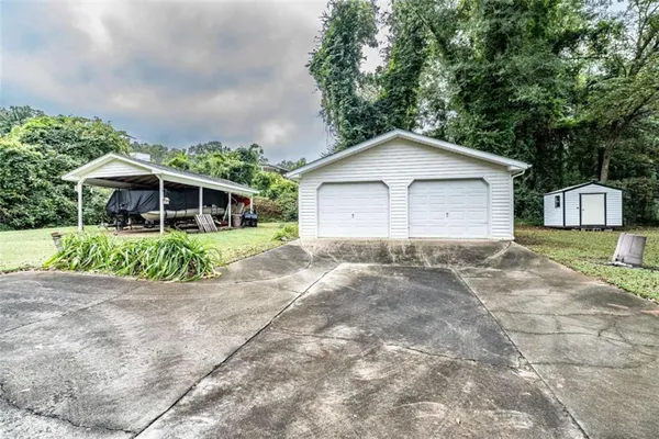 a view of a house with a yard and large trees