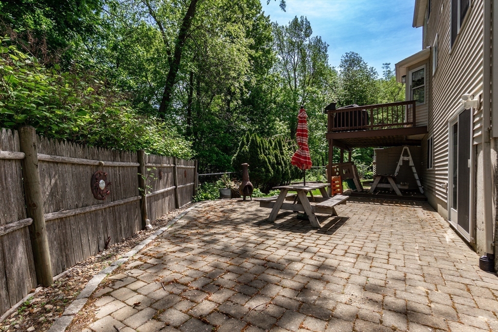 63 Bow Street Saugus, MA 01906 - Photo 37 of 42 a view of a patio with table and chairs with wooden fence and plants