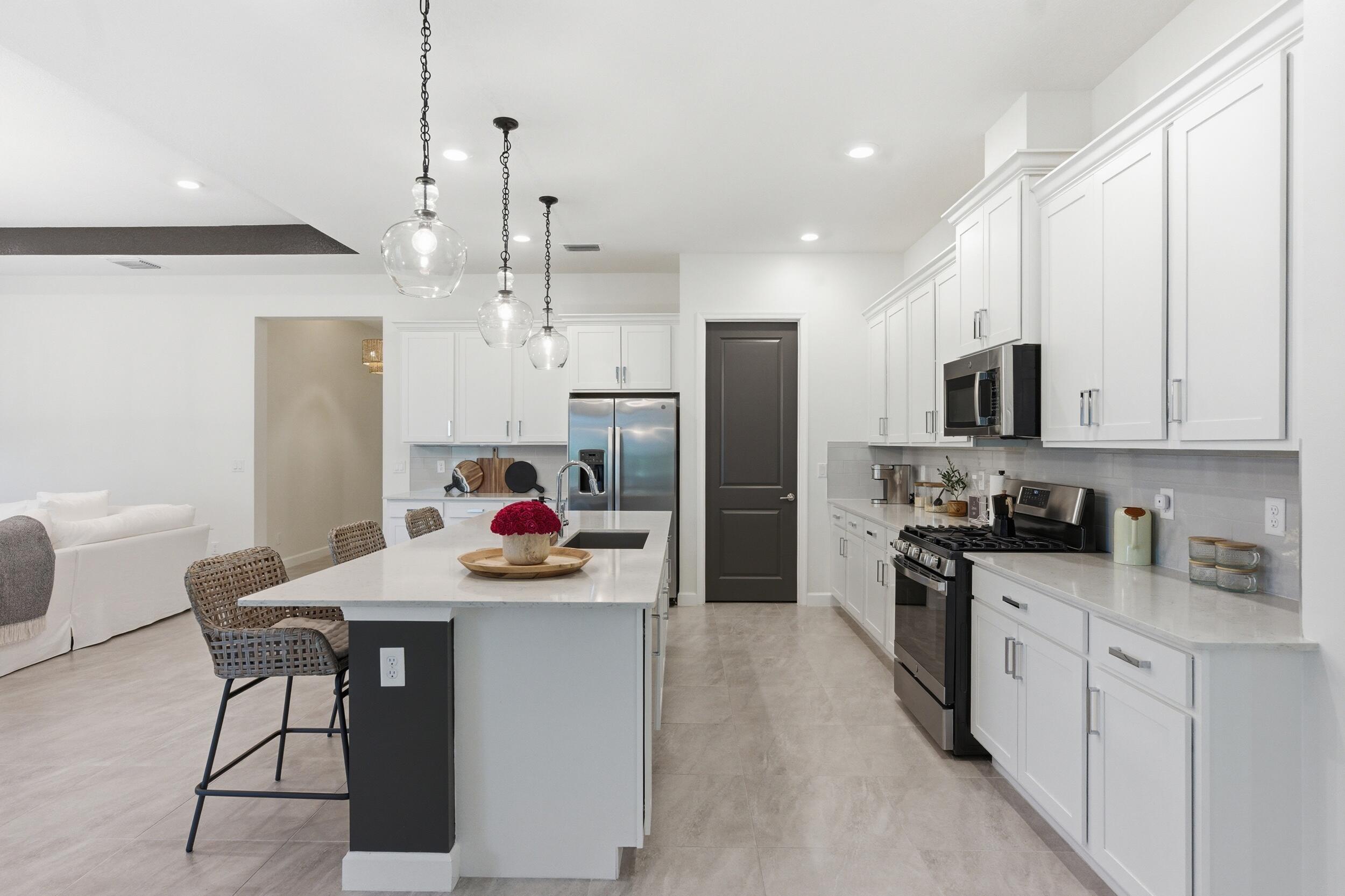 19230 Rolling Acres Road Loxahatchee, FL 33470 - Photo 35 of 58 a kitchen with stainless steel appliances kitchen island granite countertop a refrigerator and a stove top oven