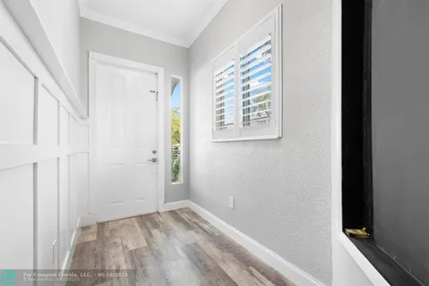 a view of a small space with wooden floor and a window