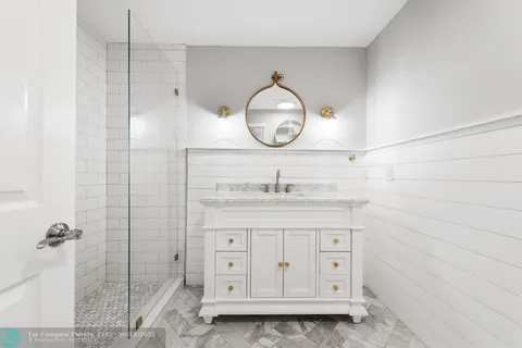 a bathroom with a granite countertop sink a toilet and a mirror