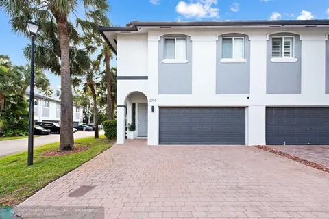 a front view of a house with a yard and trees