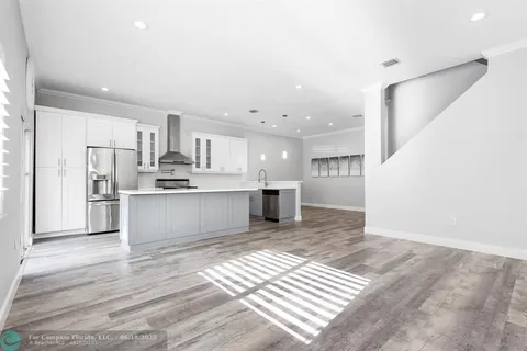 a large kitchen with kitchen island a sink stainless steel appliances and cabinets