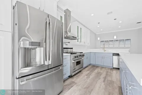 a kitchen with stainless steel appliances white cabinets and wooden floors