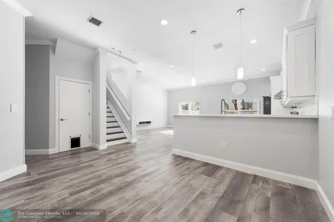 a view of kitchen and hall with wooden floor