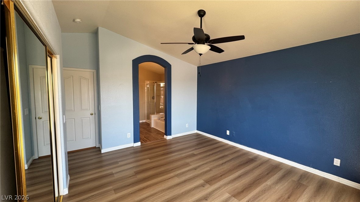 9716 Ridge Creek Place Las Vegas, NV 89134 - Photo 21 of 28 This spacious bedroom features wood flooring, a ceiling fan, and an en-suite bathroom.