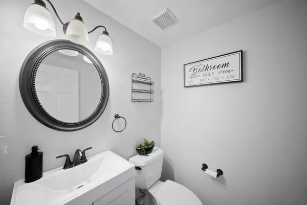 a bathroom with a toilet a sink and mirror