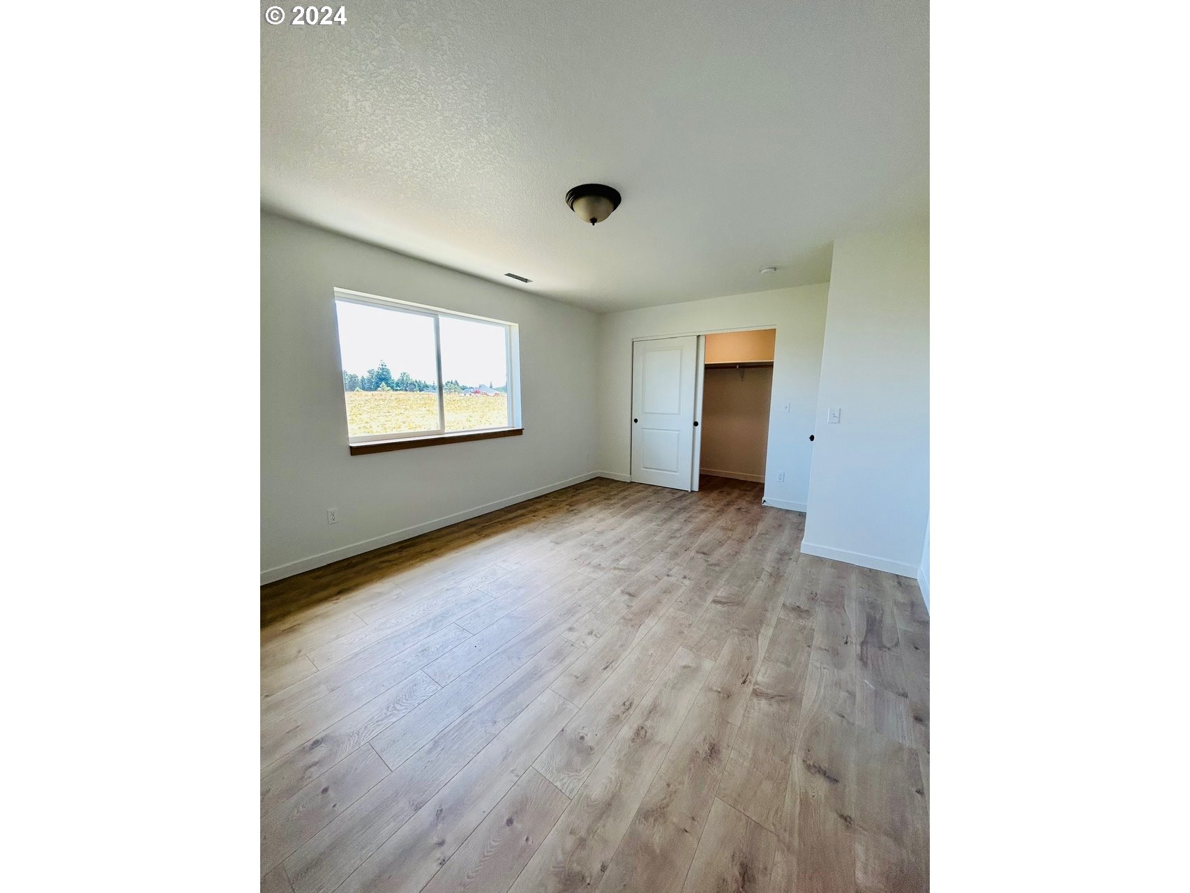1016 Peach Road Winlock, WA 98596 - Photo 25 of 43 a view of an empty room with wooden floor and a window