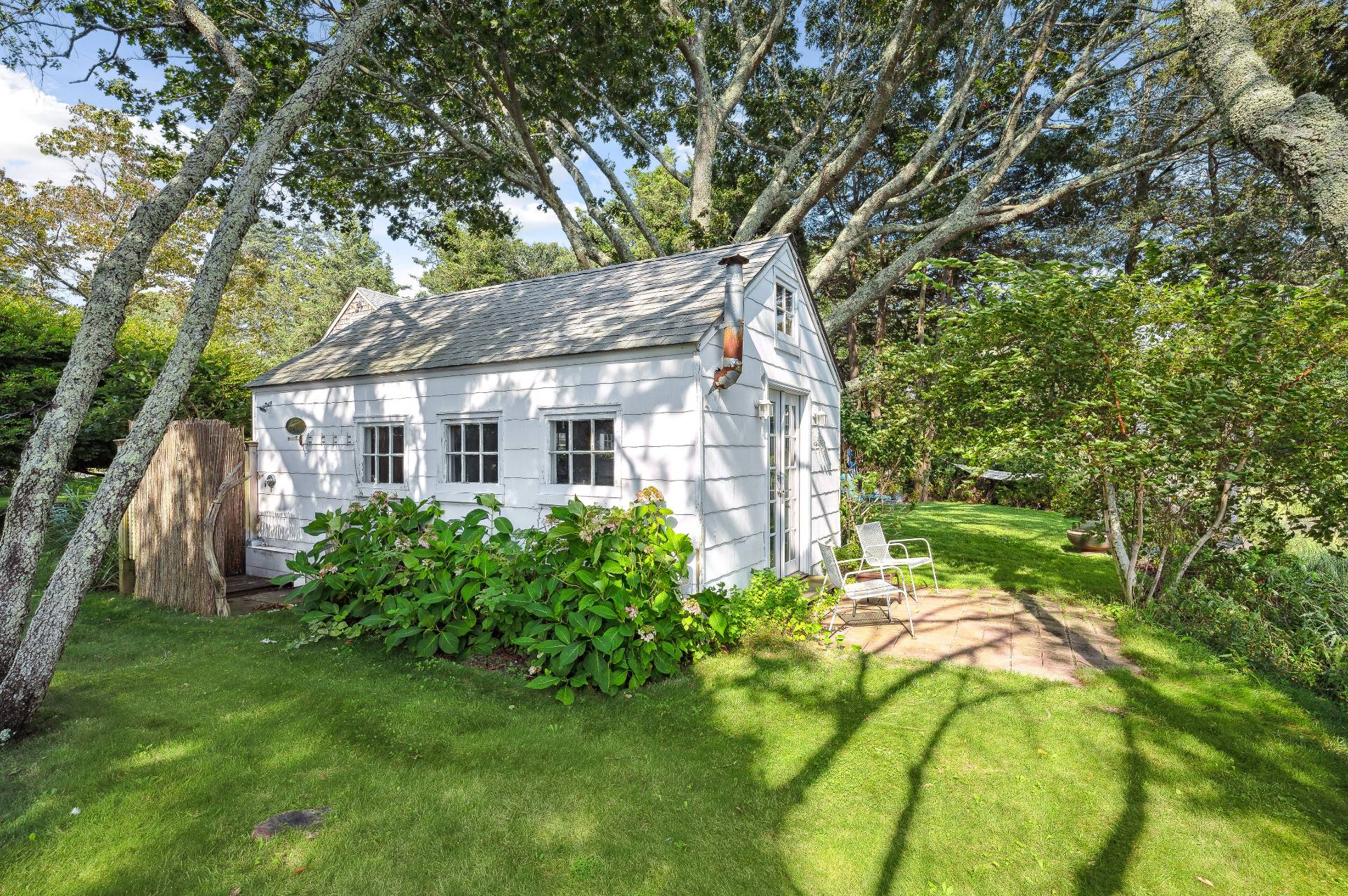 64 Towd Point Road Southampton, NY 11968 - Photo 20 of 21 a backyard of a house with plants and large trees