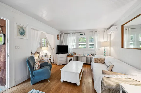 a living room with furniture flat screen tv and window