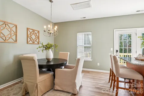 a dining room with furniture a chandelier and wooden floor