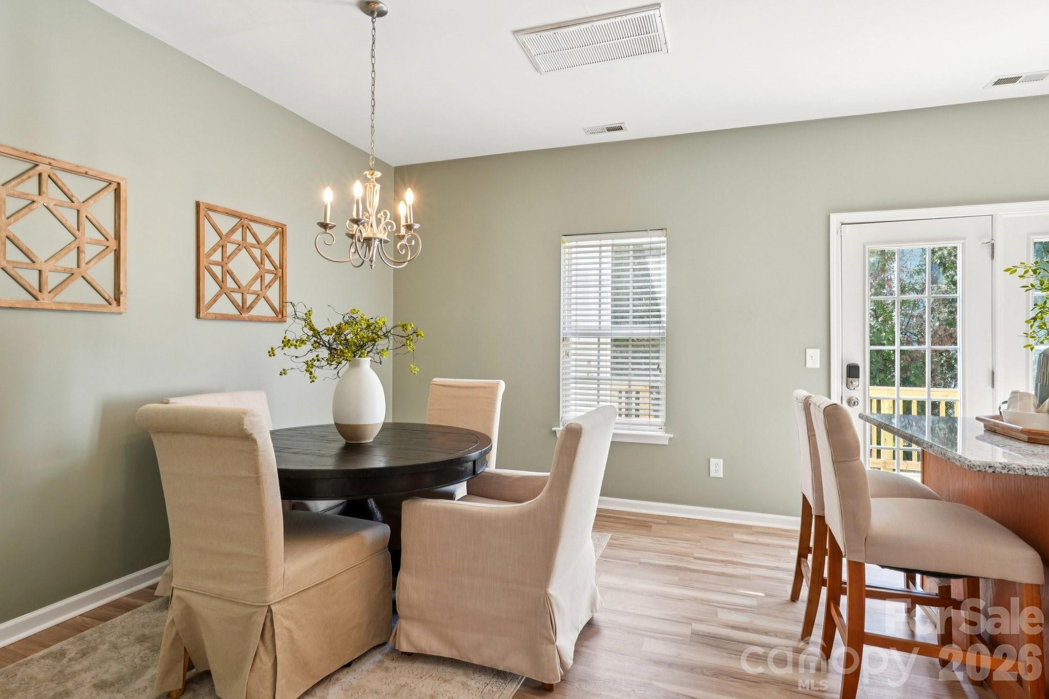 209 Township Drive Fort Mill, SC 29715 - Photo 4 of 31 a dining room with furniture a chandelier and wooden floor