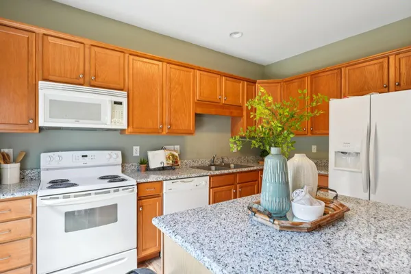 a kitchen with a stove a sink cabinetry and a refrigerator
