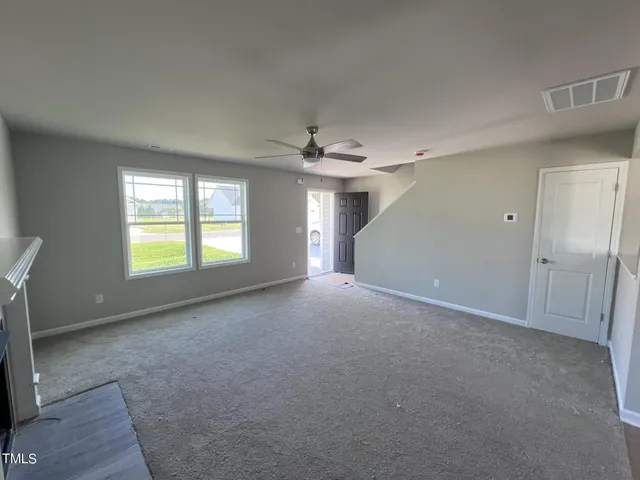 a view of a livingroom with a ceiling fan and window