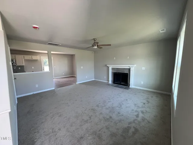 an empty room with a fireplace and a window
