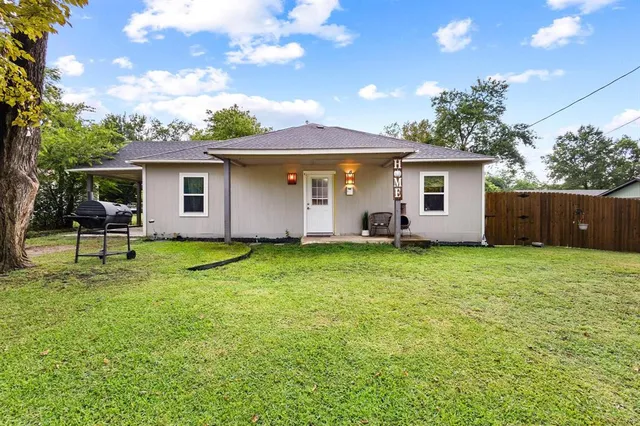 a backyard of a house with table and chairs
