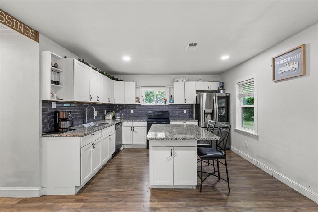 221 Braz Street Bonham, TX 75418 - Photo 10 of 26 a kitchen with granite countertop a sink appliances cabinets and wooden floor