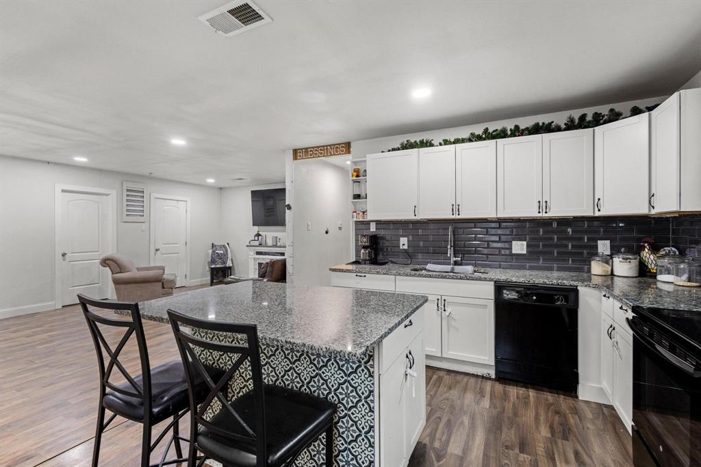 221 Braz Street Bonham, TX 75418 - Photo 12 of 26 a kitchen with stainless steel appliances granite countertop a stove a sink a refrigerator a microwave and white cabinets