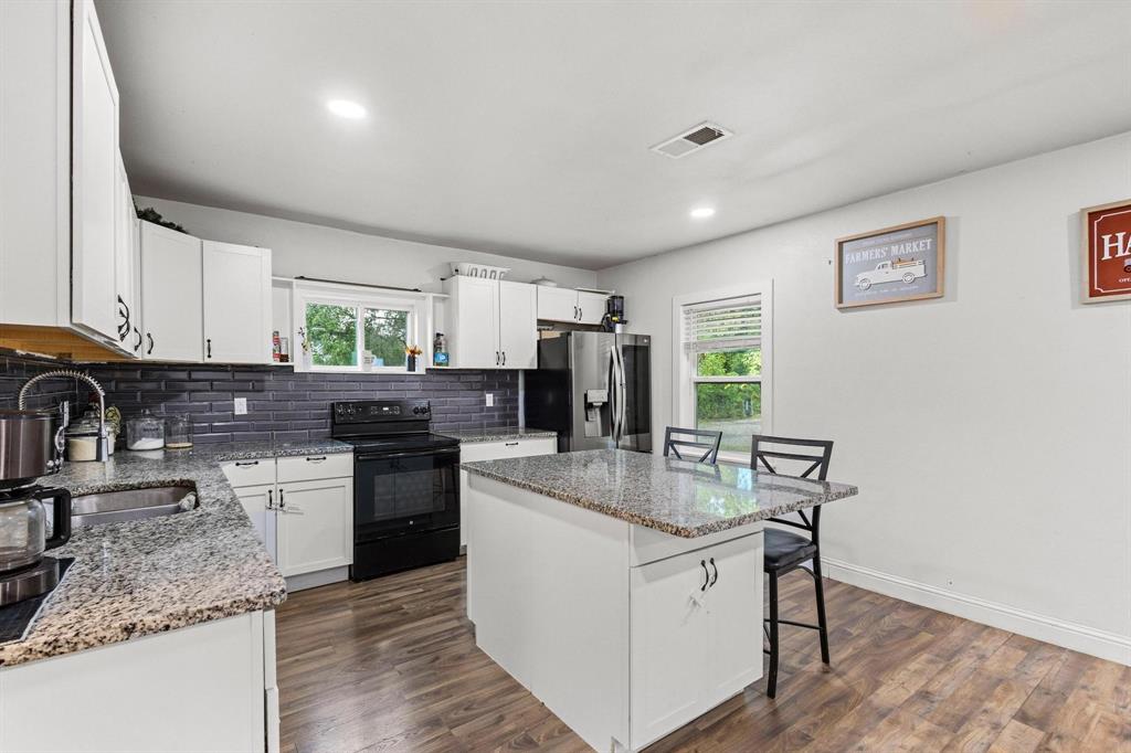 221 Braz Street Bonham, TX 75418 - Photo 13 of 26 a kitchen with stainless steel appliances granite countertop a sink stove and refrigerator
