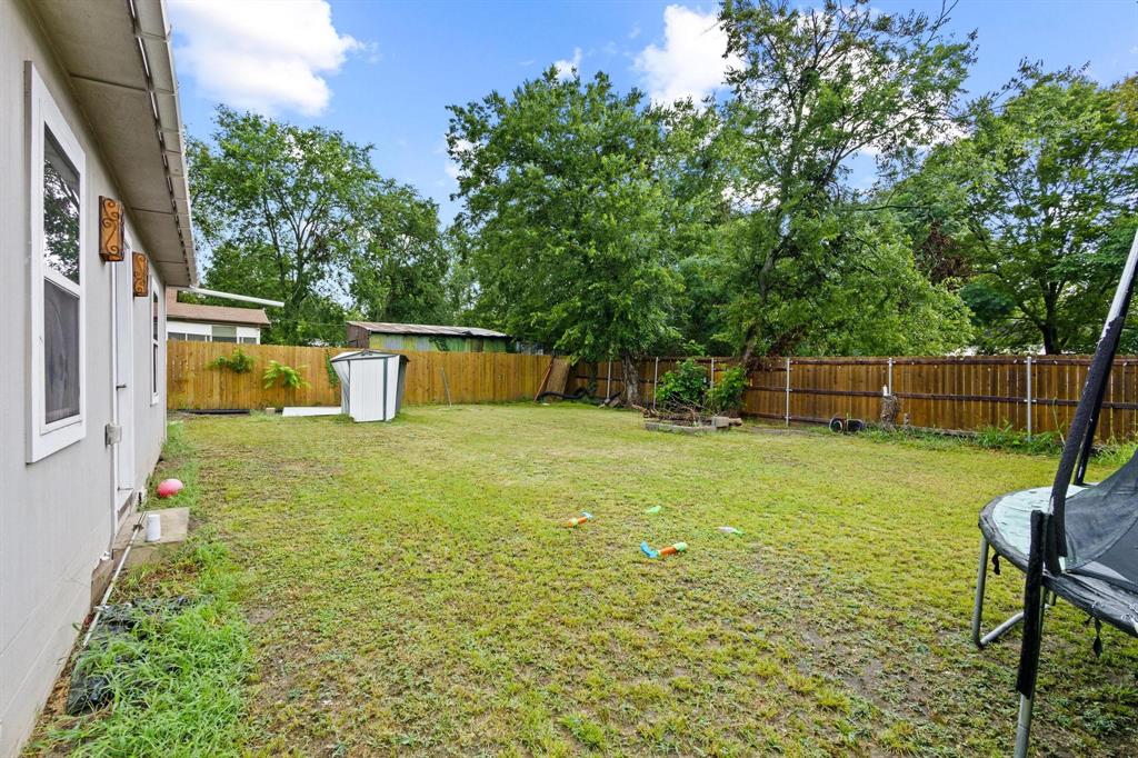 221 Braz Street Bonham, TX 75418 - Photo 23 of 26 a view of a garden with a bench