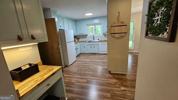 a kitchen with refrigerator cabinets and wooden floor