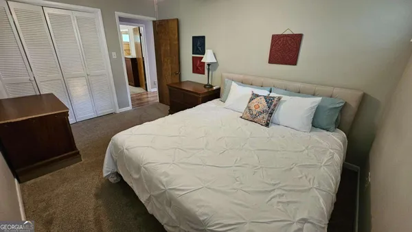 a bedroom with a bed and a flat tv screen on a dresser