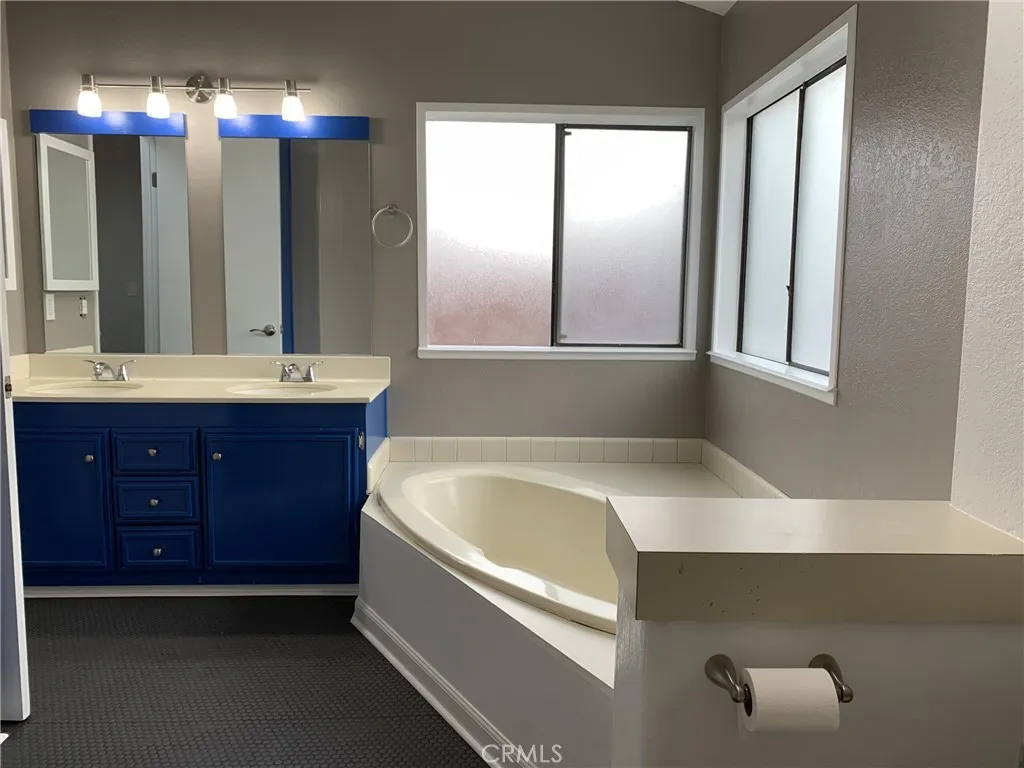 47800 Madison Street Indio, CA 92201 - Photo 16 of 28 a bathroom with a tub a double vanity sink and a mirror