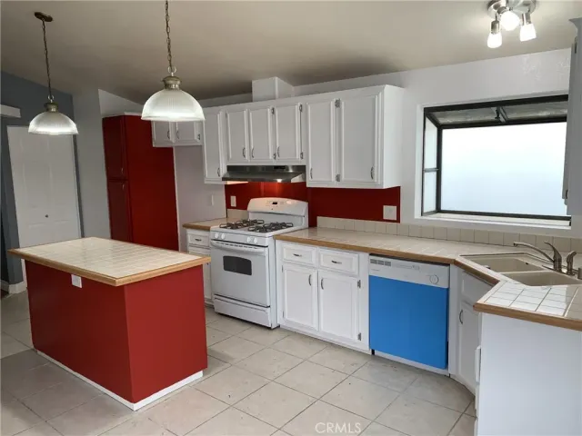 a kitchen that has a sink a stove and a wooden floor