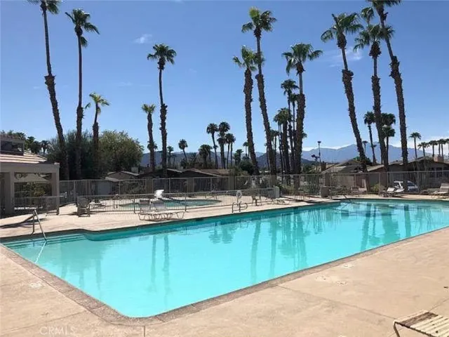 a view of a swimming pool with outdoor seating and lake view