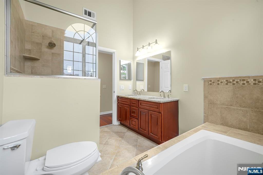 67 Davenport Road Montville, NJ 07045 - Photo 17 of 32 a bathroom with a granite countertop sink toilet a mirror and shower